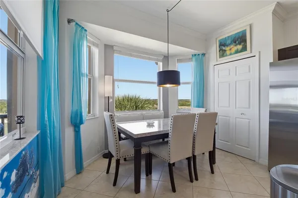a kitchen with a refrigerator a dining table and chairs