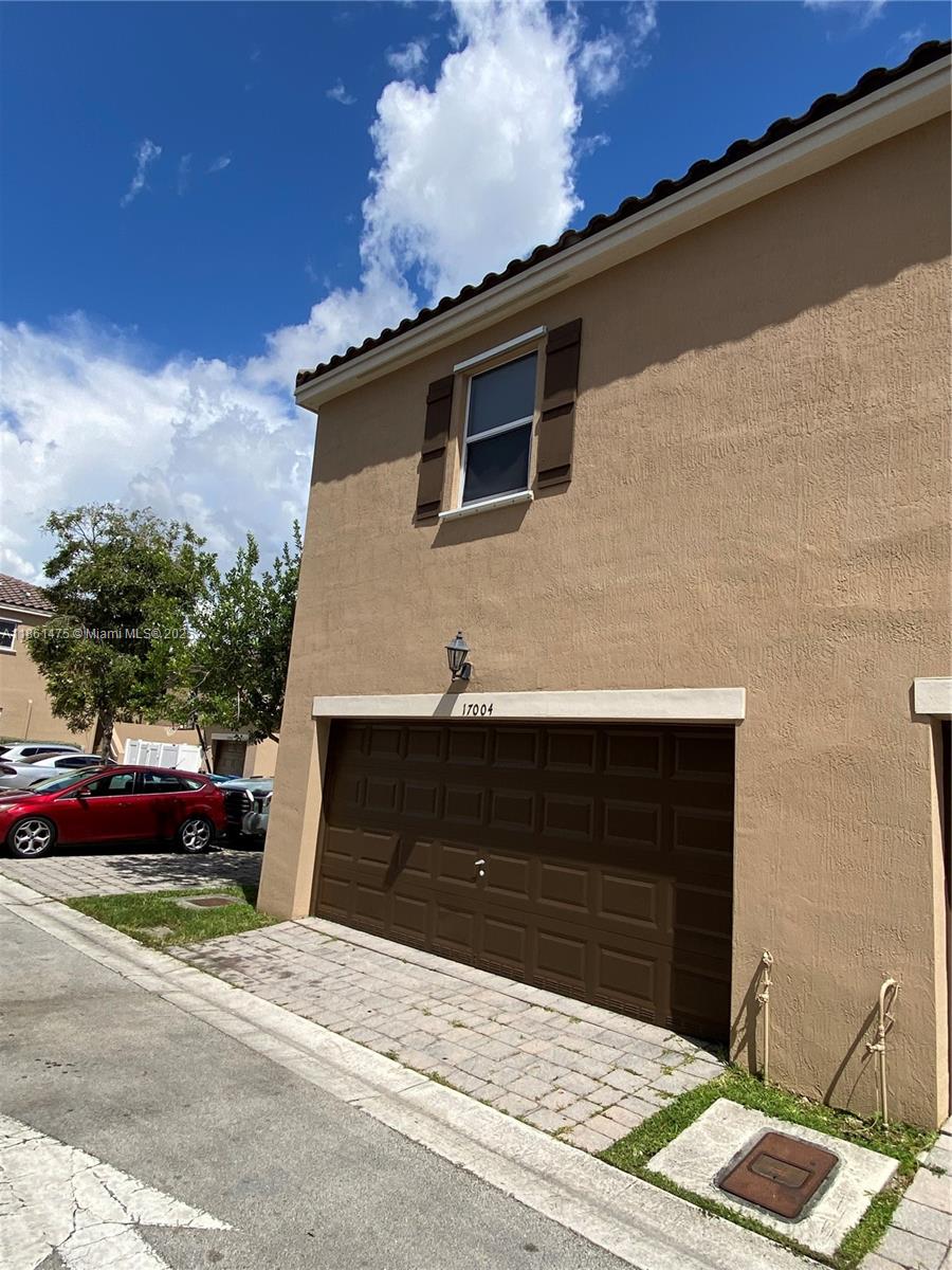 17004 Southwest 95th Terrace Miami, FL 33196 - Photo 7 of 15 a front view of a house with a yard