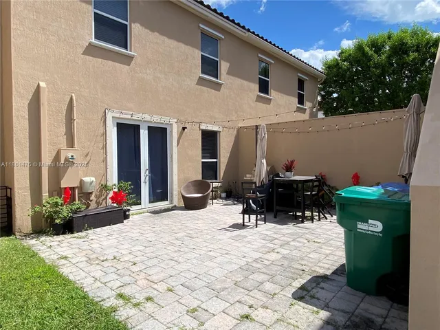 a view of a patio with a table and chairs and potted plants