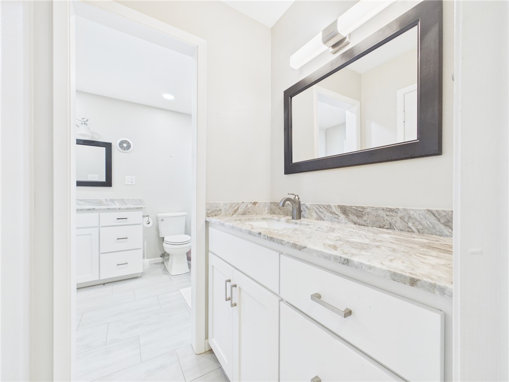 902 Briar Bend Court Bryan, TX 77802 - Photo 19 of 39 a en suite bathroom with a granite countertop sink and a mirror
