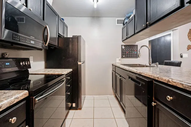 a kitchen with stainless steel appliances granite countertop a sink and a stove