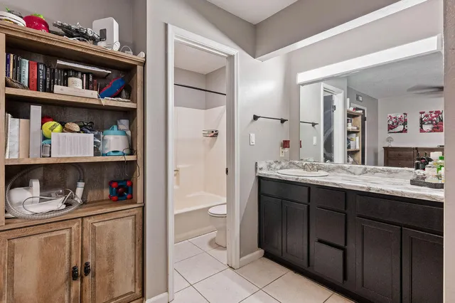 a bathroom with a granite countertop sink vanity and a toilet