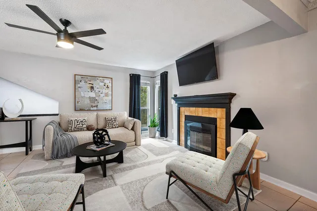 a living room with furniture a fireplace and a flat screen tv