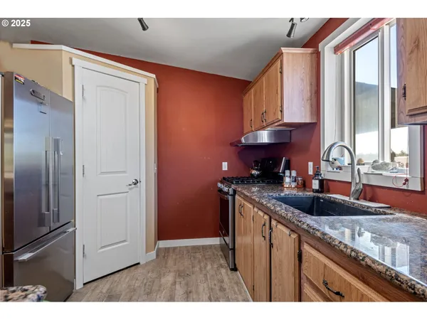 a kitchen with stainless steel appliances granite countertop a sink stove and refrigerator