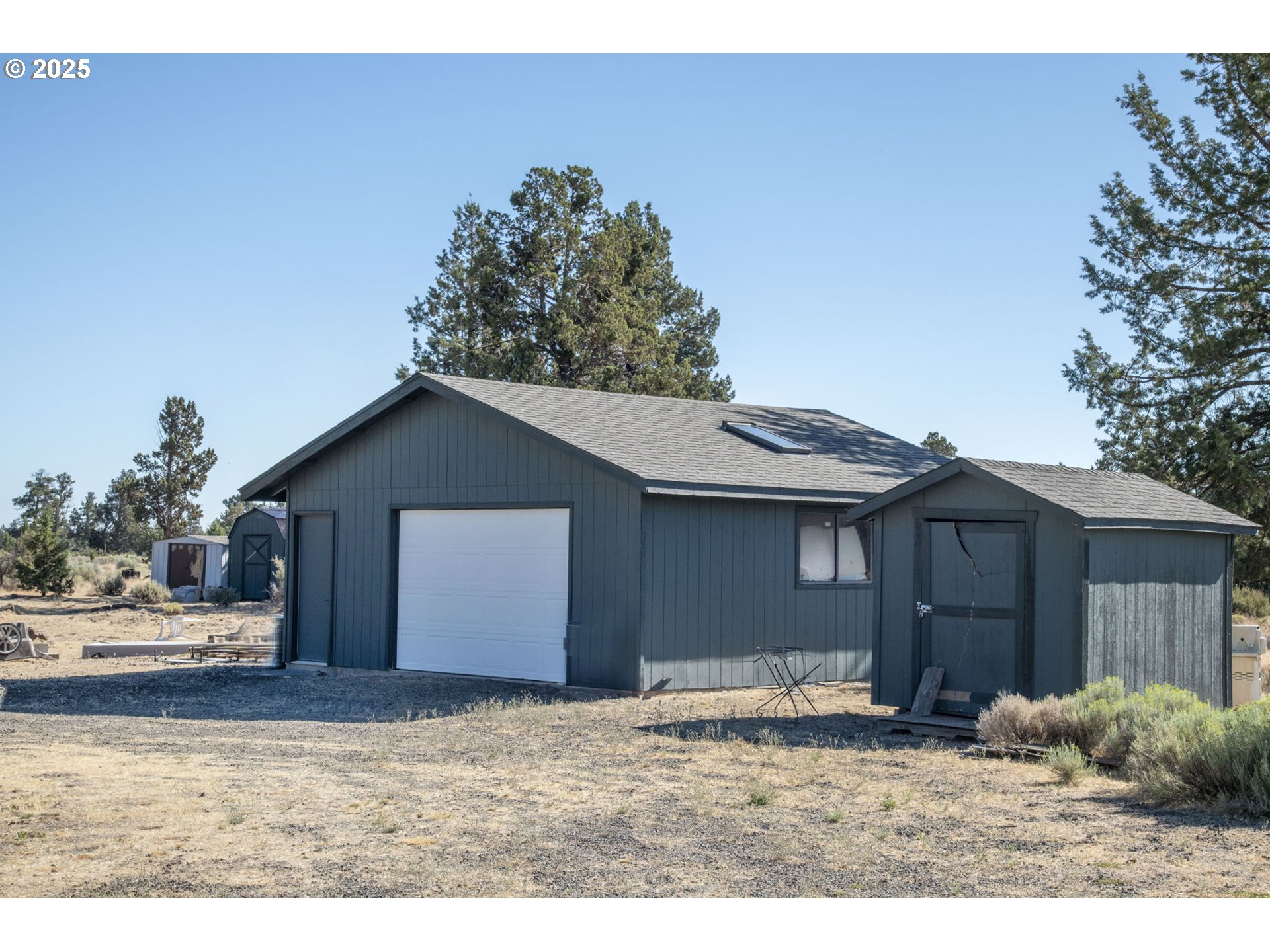12510 Southwest Geneva Road Culver, OR 97734 - Photo 20 of 47 a backyard of a house with large trees and wooden fence
