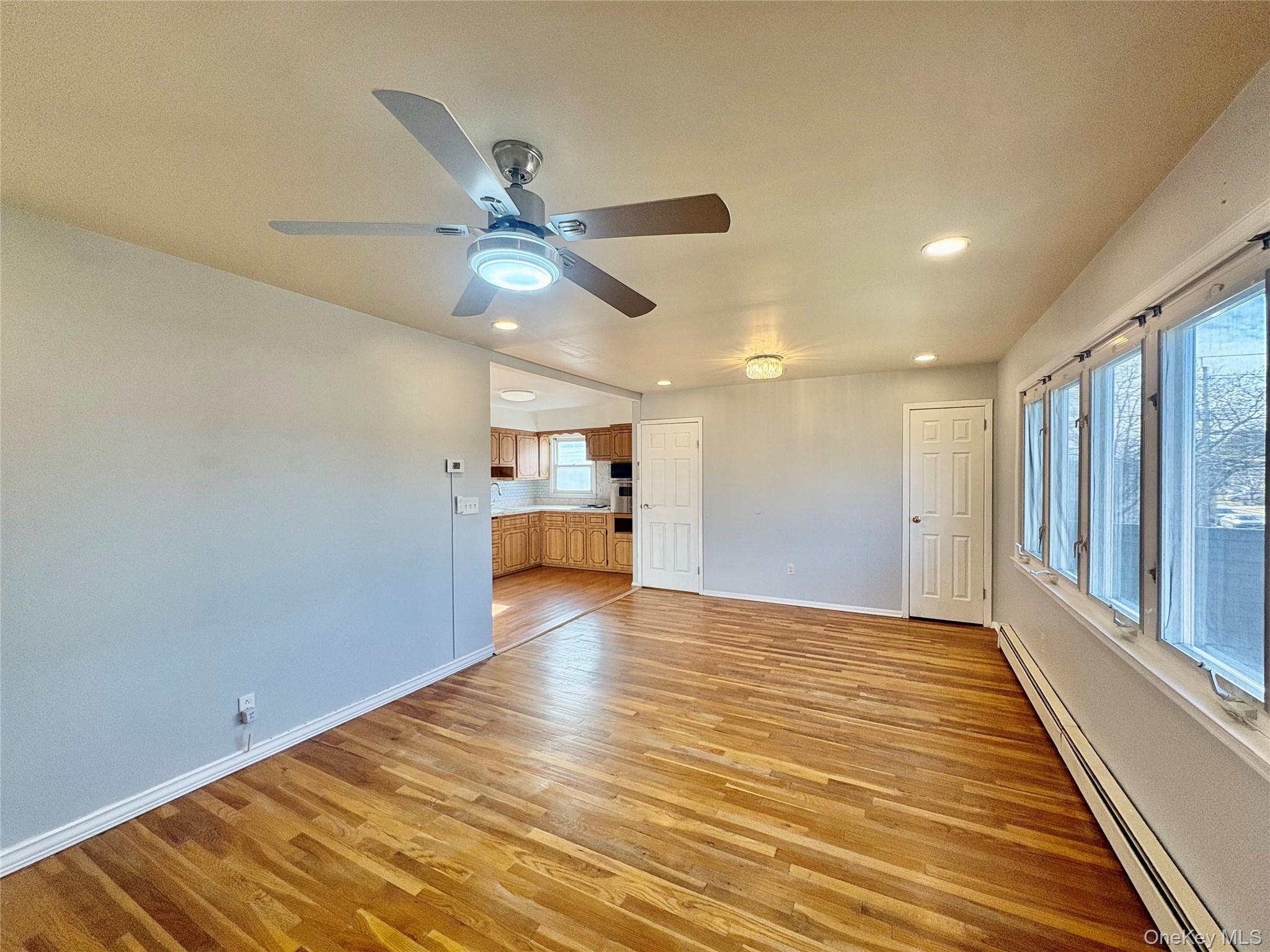 Undisclosed Address Valley Stream, NY 11581 - Photo 4 of 11 a view of a livingroom with a ceiling fan & hardwood floor