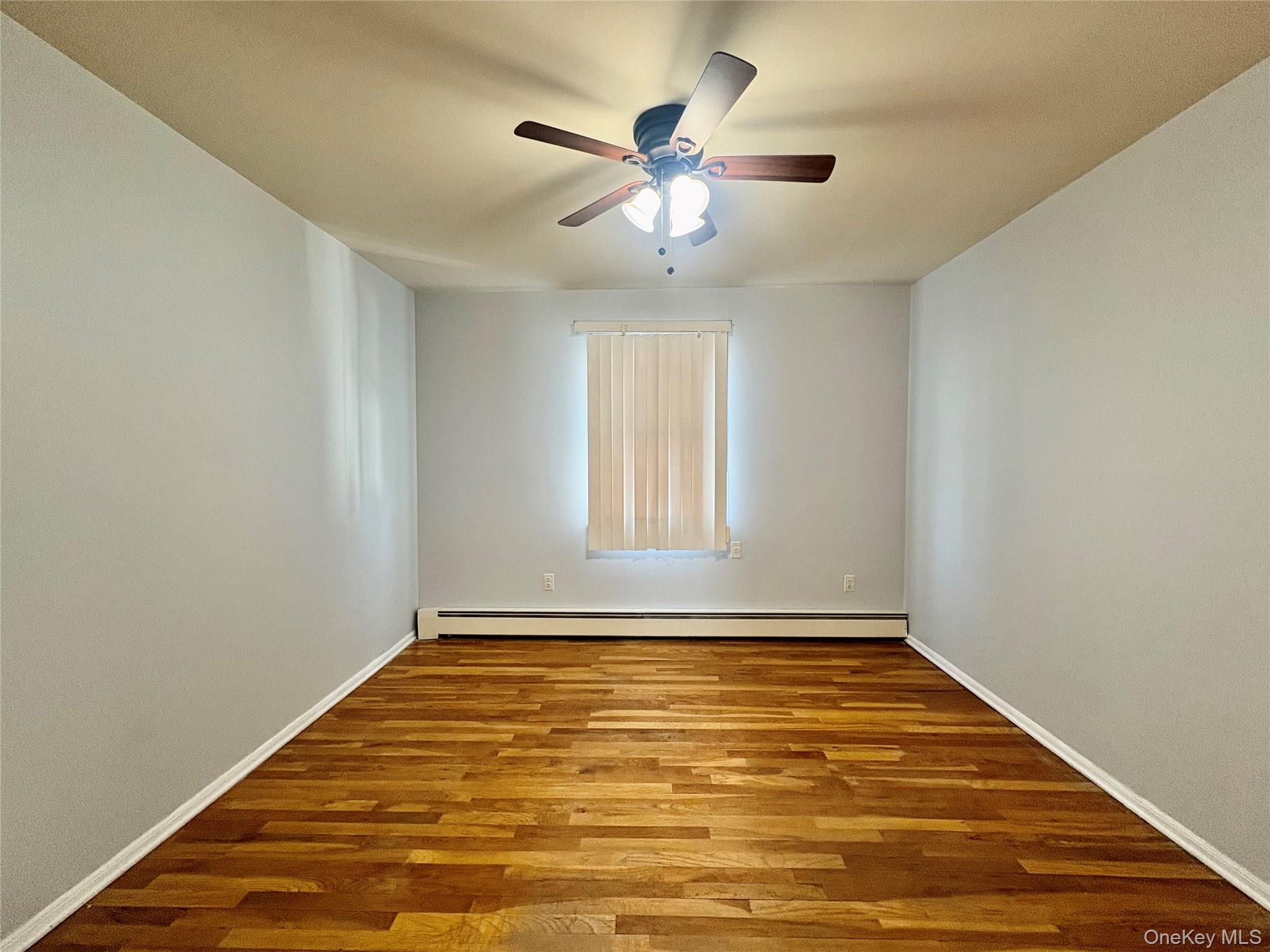 Undisclosed Address Valley Stream, NY 11581 - Photo 8 of 11 an empty room with window and ceiling fan