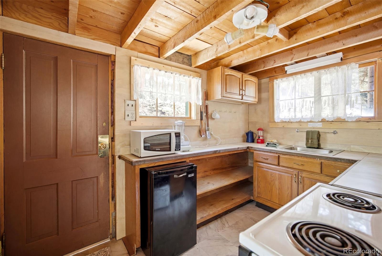 652 Payne Gulch Road Bailey, CO 80421 - Photo 16 of 33 a kitchen that has a sink a stove and cabinets