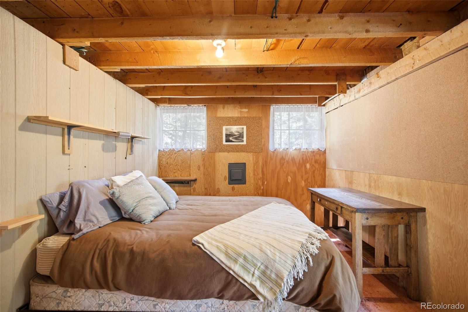 652 Payne Gulch Road Bailey, CO 80421 - Photo 21 of 33 a bedroom with a bed and a table