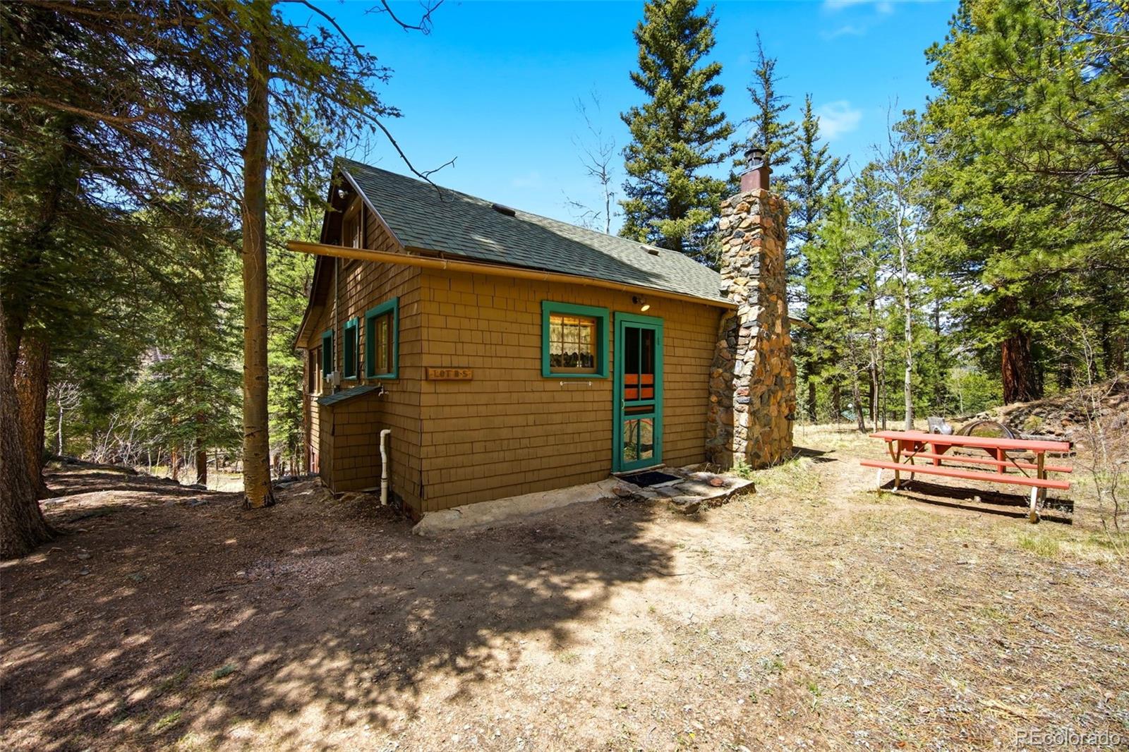 652 Payne Gulch Road Bailey, CO 80421 - Photo 24 of 33 a backyard of a house with fire pit and trees