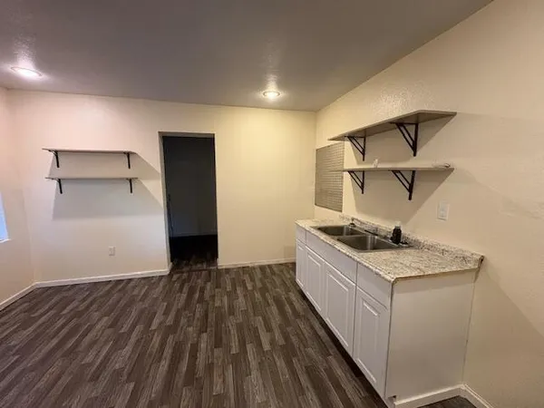 a kitchen with a sink and wooden floor