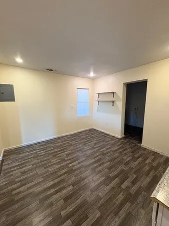 a view of empty room with wooden floor