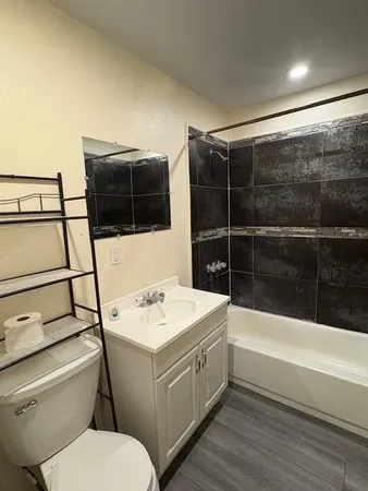 a bathroom with a sink a toilet and shower