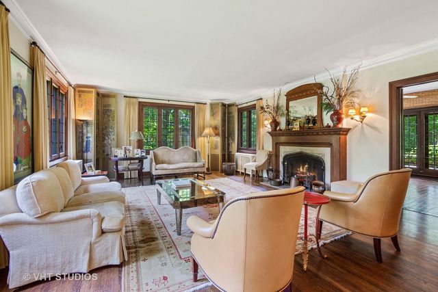 a living room with furniture a fireplace and a floor to ceiling window