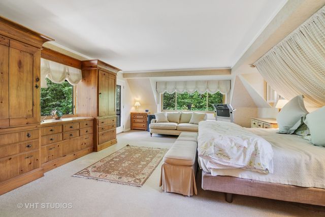 a bedroom with furniture and a large window