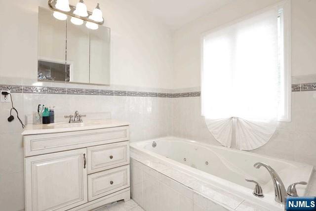 84 12th Street Cresskill, NJ 07626 - Photo 33 of 45 a bathroom with a bathtub a sink and a window