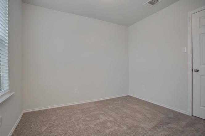148 Spotted Rail Ridge Leander, TX 78641 - Photo 27 of 31 A well-lit, neutral-toned room featuring plush carpeting and clean, simple finishes.