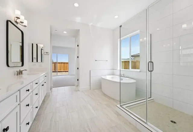 a bathroom with a tub sink and mirror