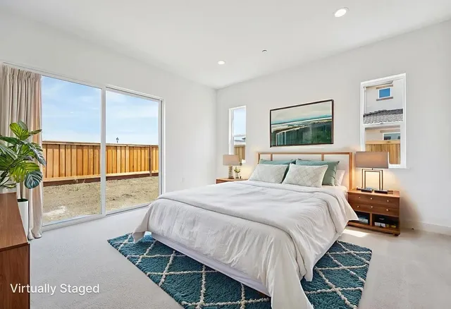 a spacious bedroom with a bed a dresser and a window