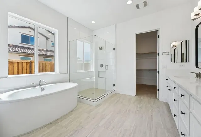 a bathroom with a tub sink shower and mirror