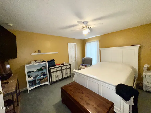 a spacious bedroom with a bed and a chandelier