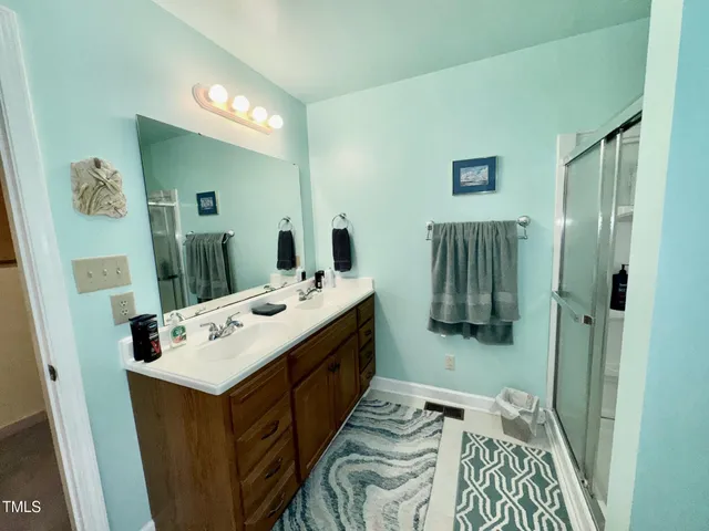 a en suite bathroom with a sink a mirror and shower