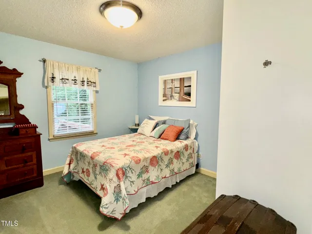 a bed sitting in a bedroom next to a window