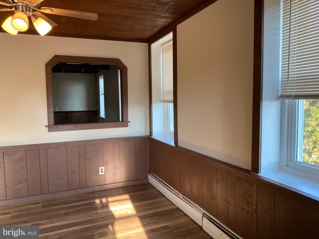 a view of a hallway with wooden floor and a window