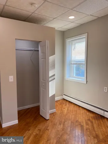 an empty room with wooden floor and a window