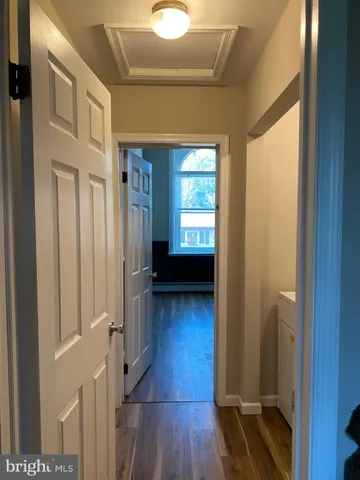 a view of a hallway with wooden floor and stairs