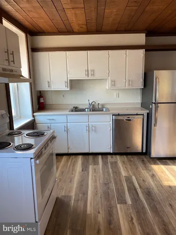 a kitchen with wooden floors and white appliances