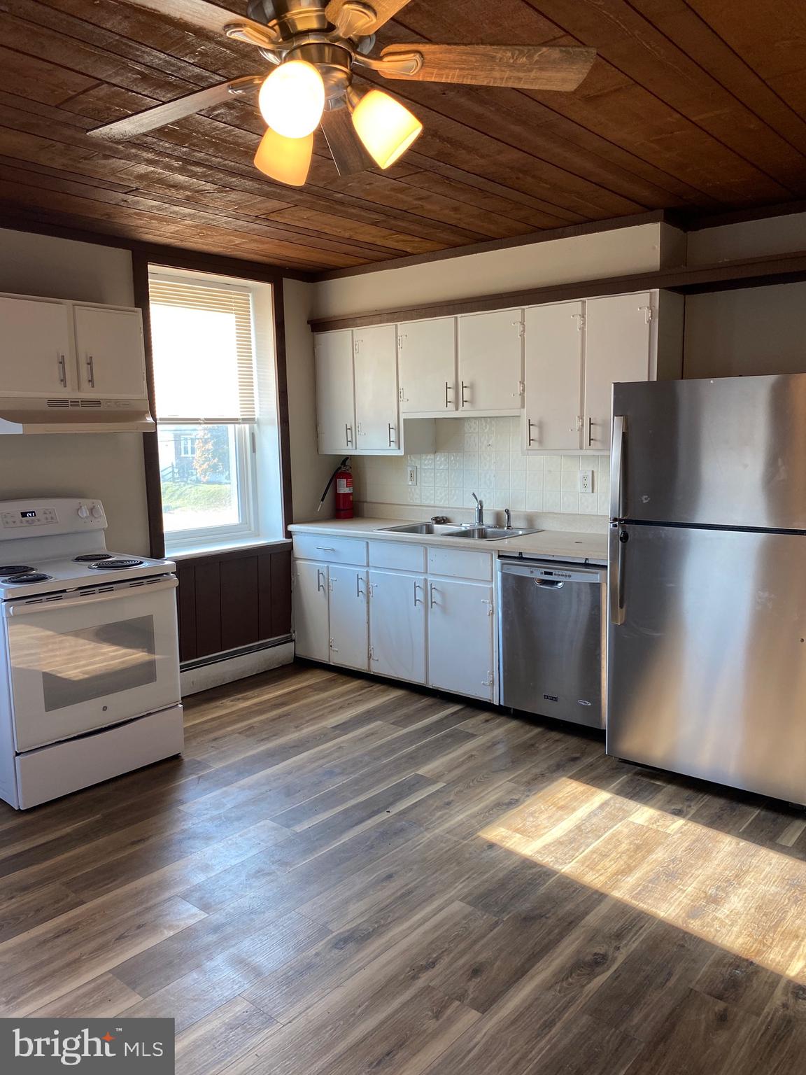 327 South Church Street, Unit 1 Spring City, PA 19475 - Photo 10 of 36 a kitchen with stainless steel appliances granite countertop a refrigerator a sink a stove and white cabinets with wooden floor