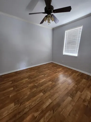 a view of empty room with wooden floor