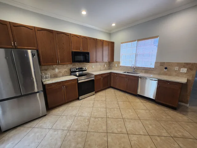 a kitchen with stainless steel appliances granite countertop a sink stove and microwave