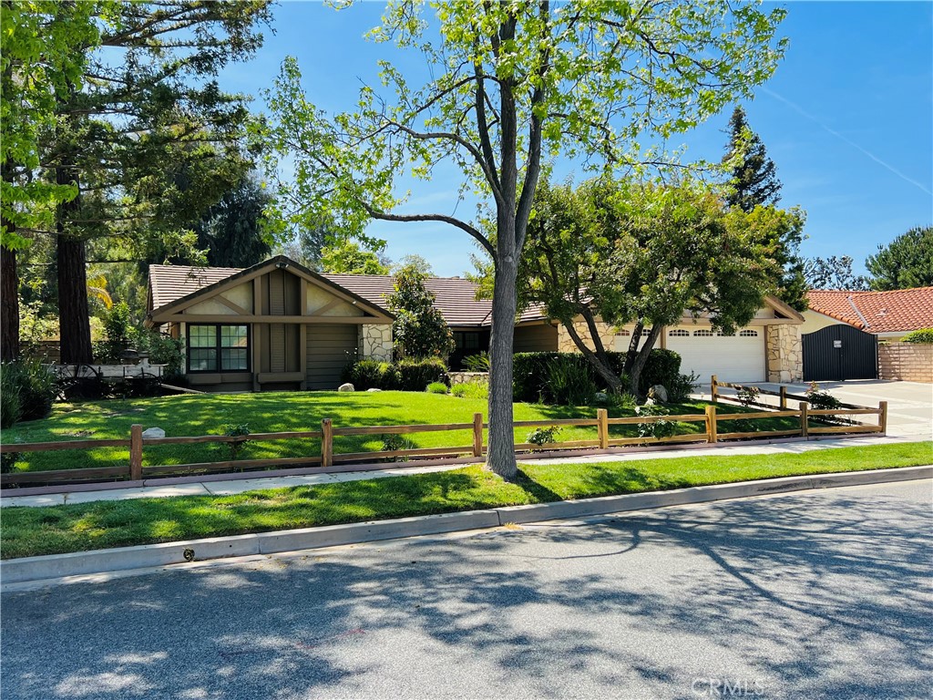 a view of a house with a big yard and large trees