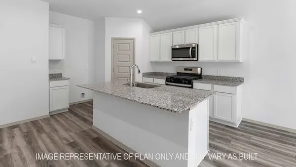a kitchen with granite countertop a stove microwave and sink