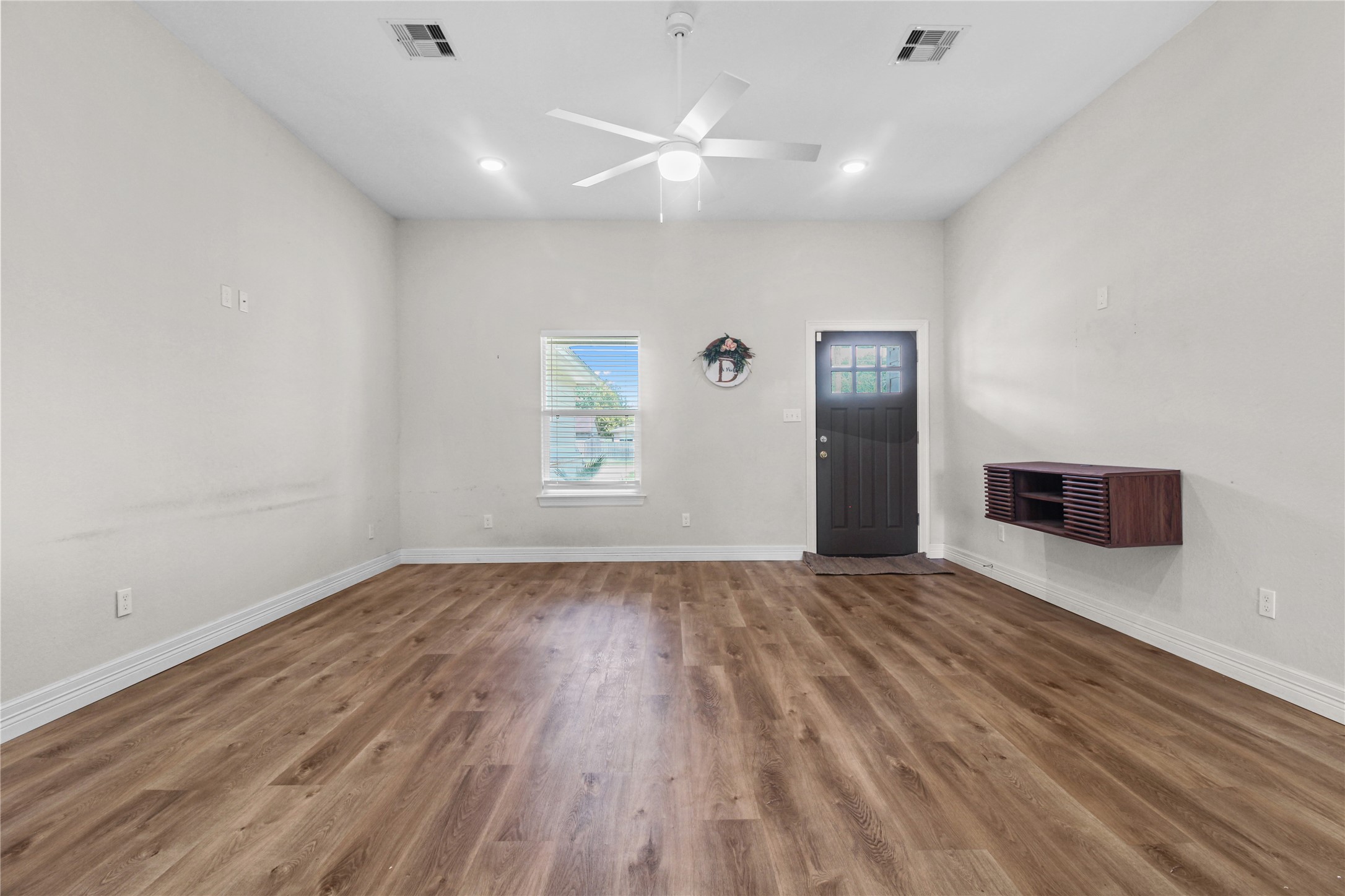 1208 East Henderson Road Angleton, TX 77515 - Photo 5 of 29 an empty room with wooden floor and windows