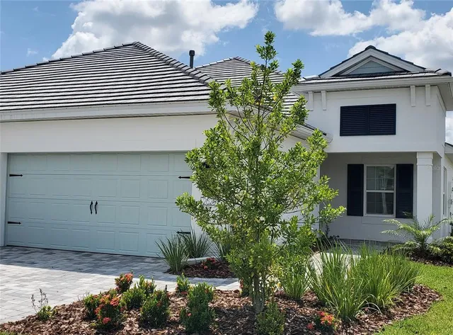 a front view of a house with plants