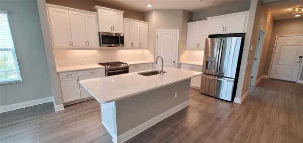 a kitchen with stainless steel appliances granite countertop a refrigerator stove top oven and sink