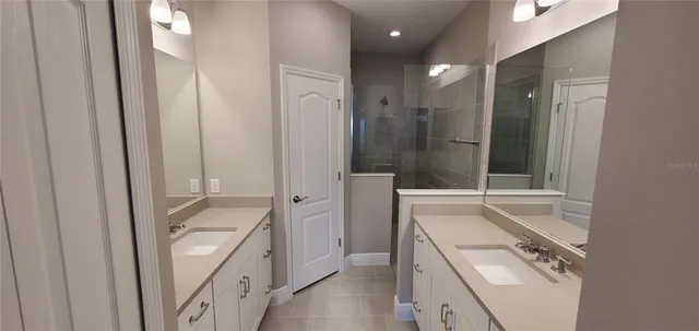 a bathroom with a granite countertop sink mirror vanity and bathtub