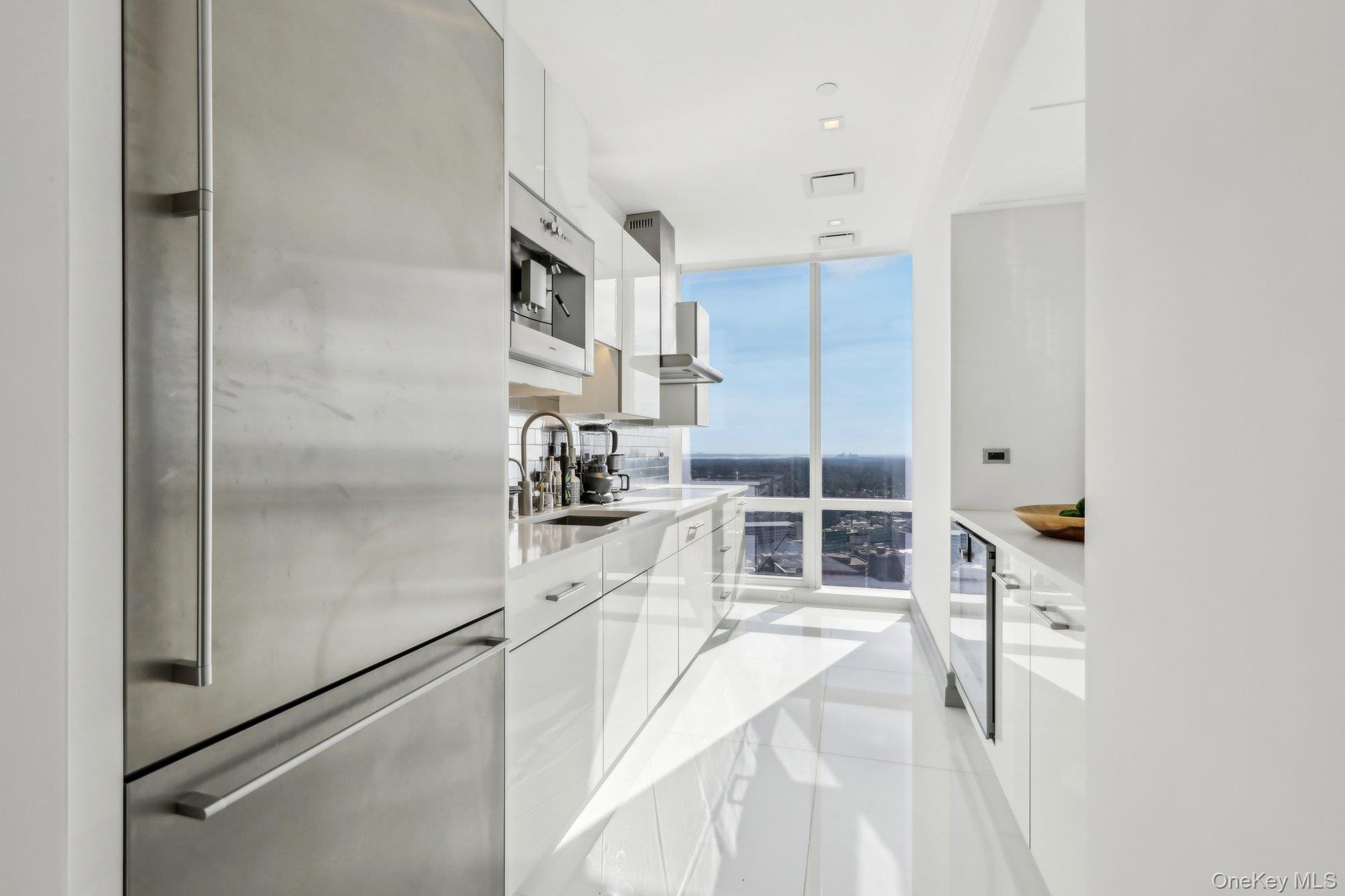 5 Renaissance Square, Unit PH41G White Plains, NY 10601 - Photo 8 of 26 a kitchen with white cabinets and white appliances