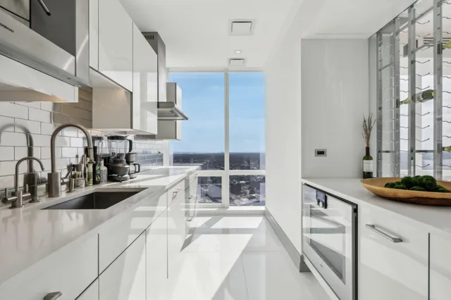 a kitchen with stainless steel appliances granite countertop a sink and a stove next to a window