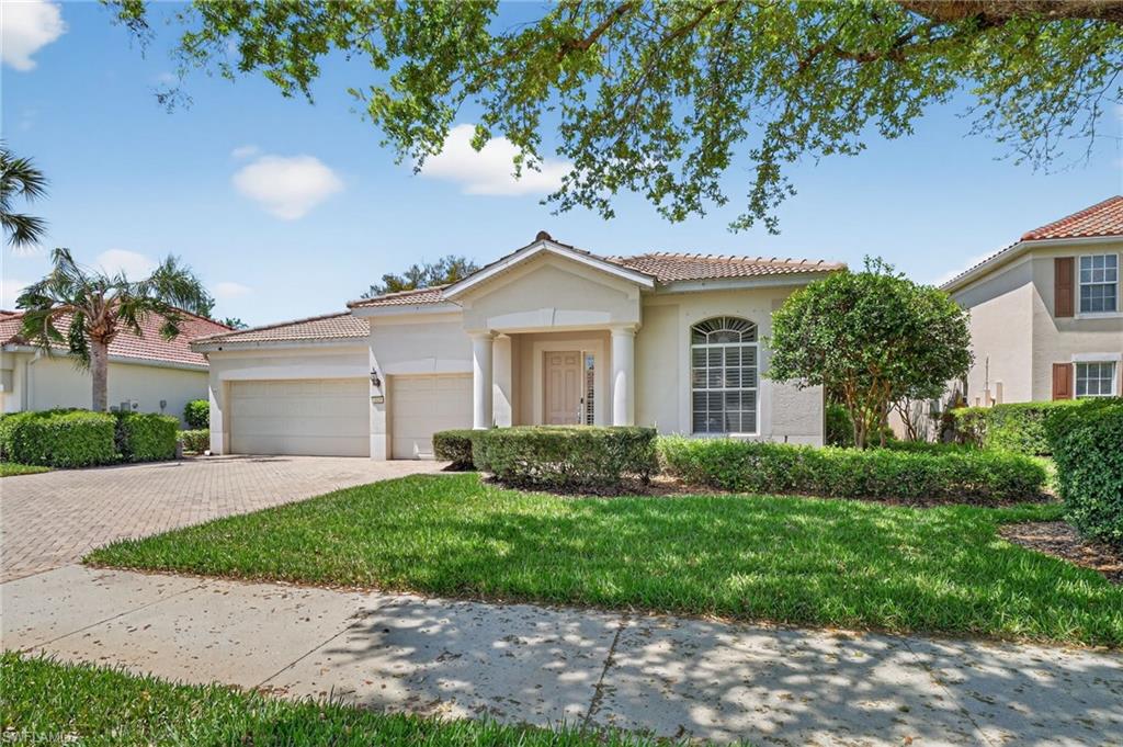 2065 Mandarin Lane Naples, FL 34120 - Photo 13 of 46 a front view of a house with a yard and garage