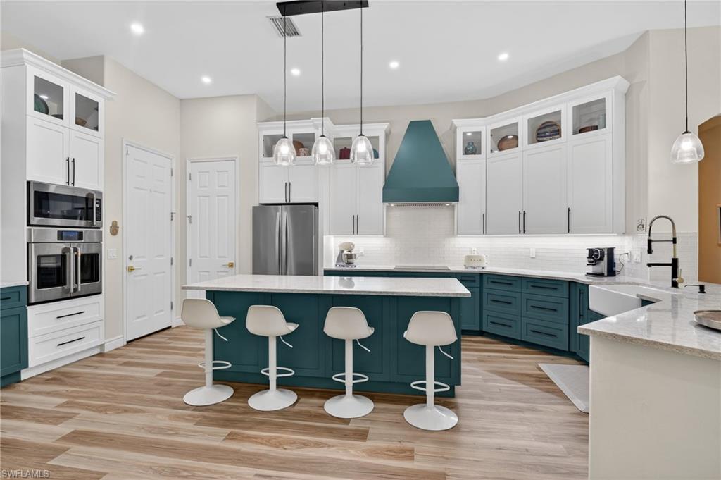 2065 Mandarin Lane Naples, FL 34120 - Photo 18 of 46 a large kitchen with a table and chairs