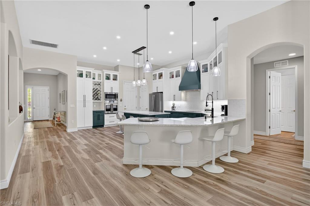 2065 Mandarin Lane Naples, FL 34120 - Photo 21 of 46 a large room with kitchen island a wooden floor and view living room