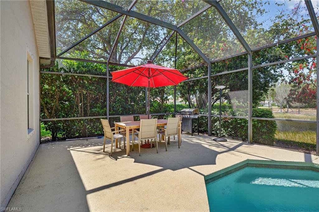 2065 Mandarin Lane Naples, FL 34120 - Photo 31 of 46 a view of a patio with couches table and chairs under an umbrella