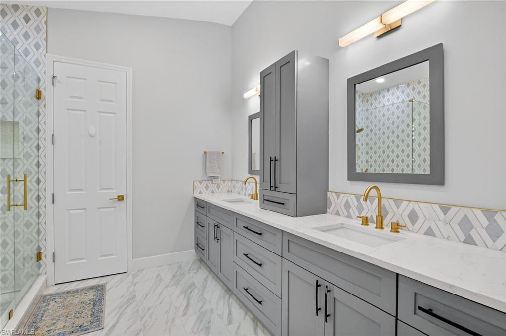 2065 Mandarin Lane Naples, FL 34120 - Photo 35 of 46 a bathroom with a double vanity sink and mirror