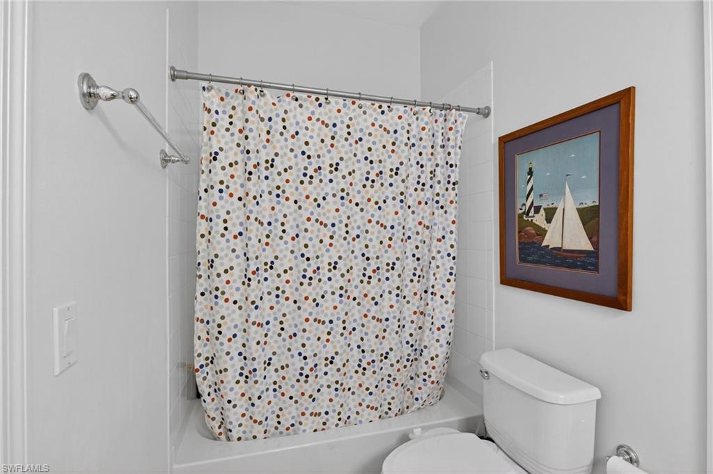 2065 Mandarin Lane Naples, FL 34120 - Photo 39 of 46 a white toilet sitting next to a shower curtain