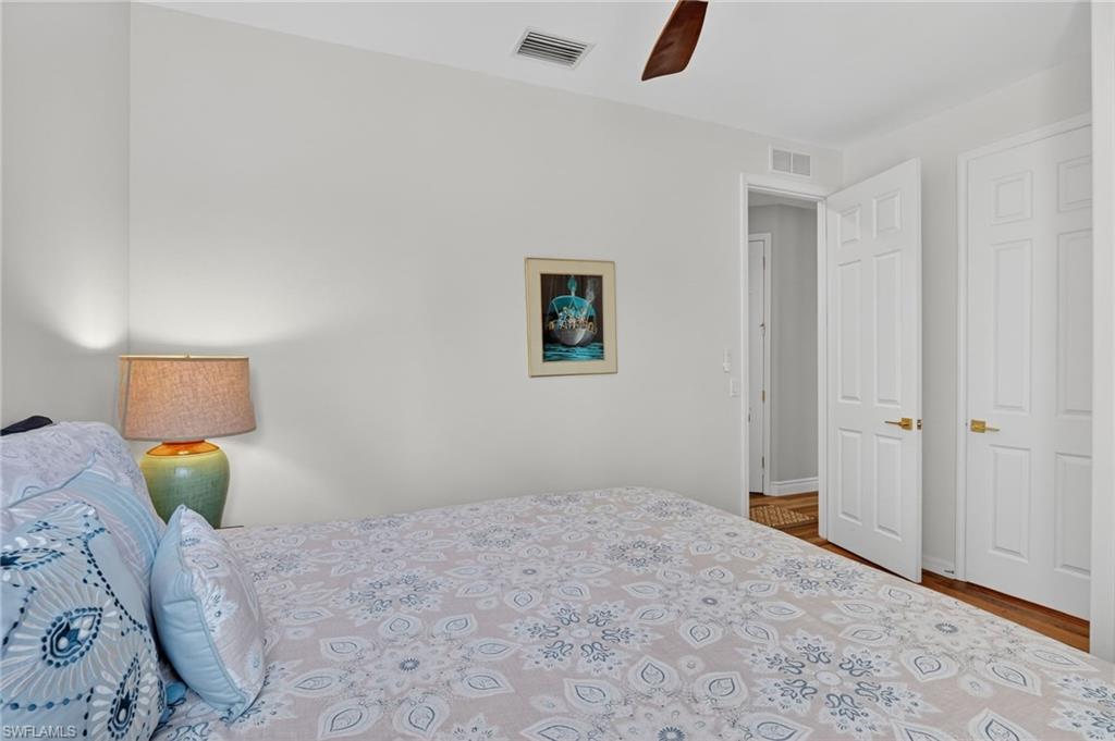 2065 Mandarin Lane Naples, FL 34120 - Photo 41 of 46 a bedroom with a bed and a lamp on dresser