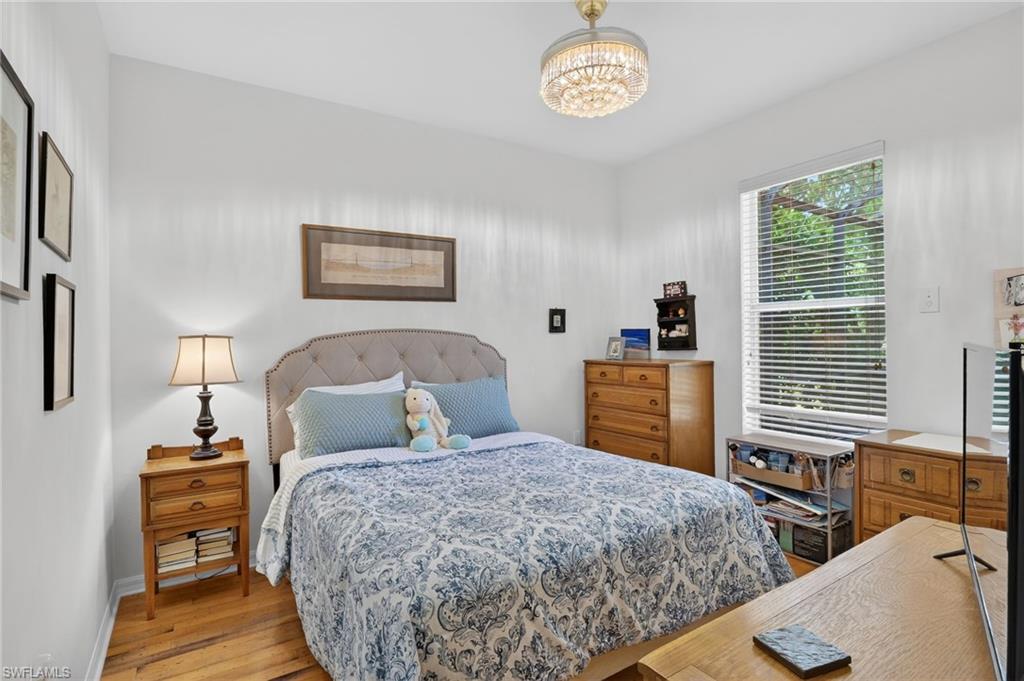 2065 Mandarin Lane Naples, FL 34120 - Photo 42 of 46 a bedroom with a bed and a table in it with window